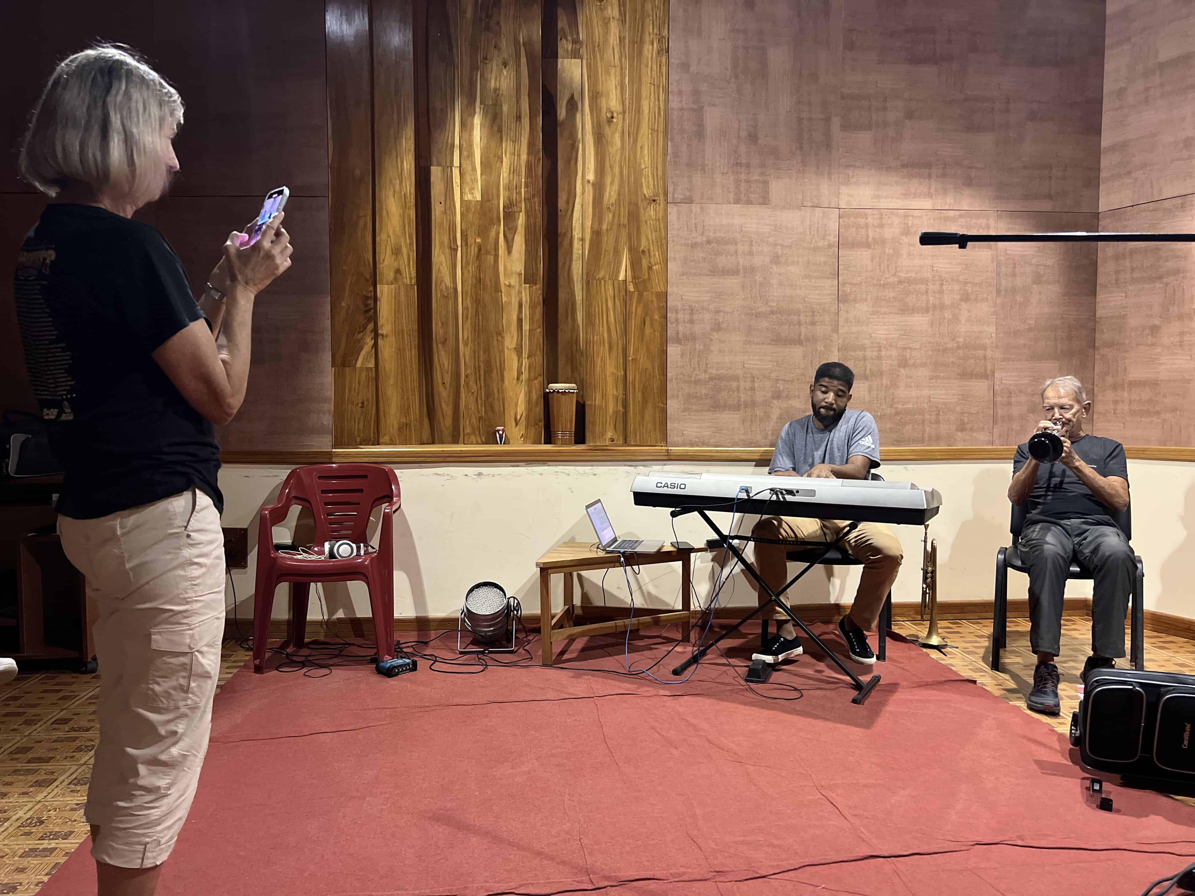 Learners listening to a pianist in a wood-paneled music room