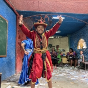 Folkloric dancer in a red costume performing with drummers in Cuba.
